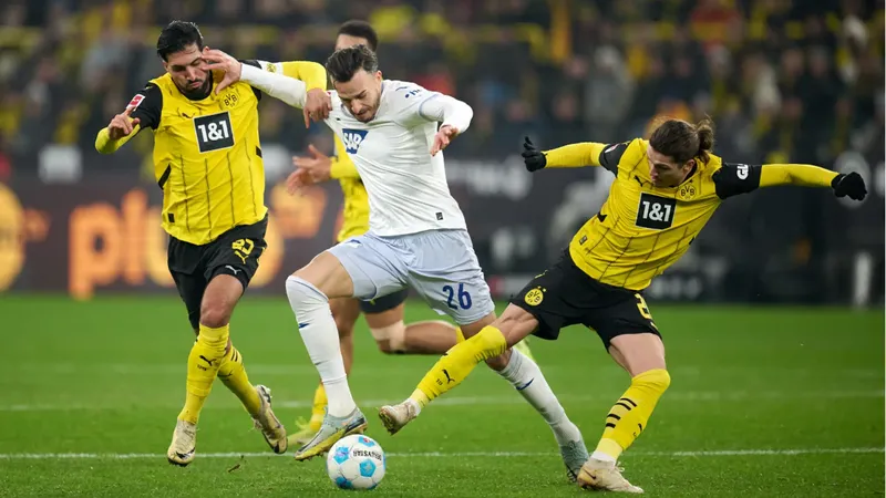Cầu thủ Dortmund dùng kỹ thuật vượt qua cầu thủ Hoffenheim trên sân cỏ Cầu thủ Dortmund dùng kỹ thuật vượt qua cầu thủ Hoffenheim trên sân cỏ